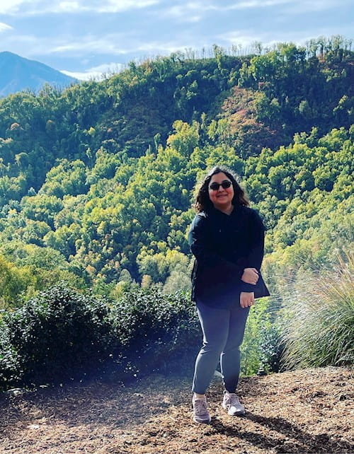 Asma standing in front of scenic, natural background